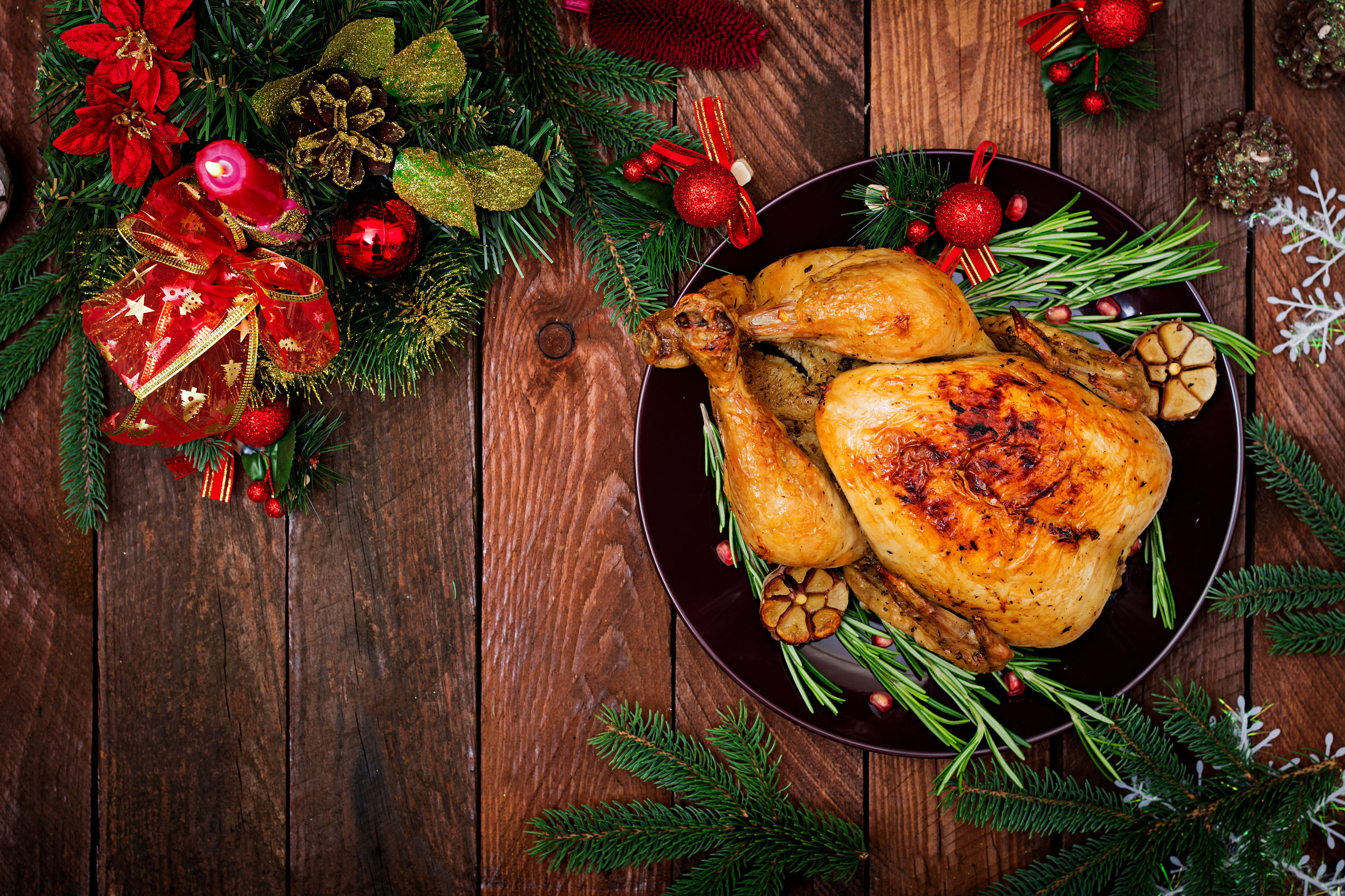 Roast turkey garnished and presented on wooden top with festive garland